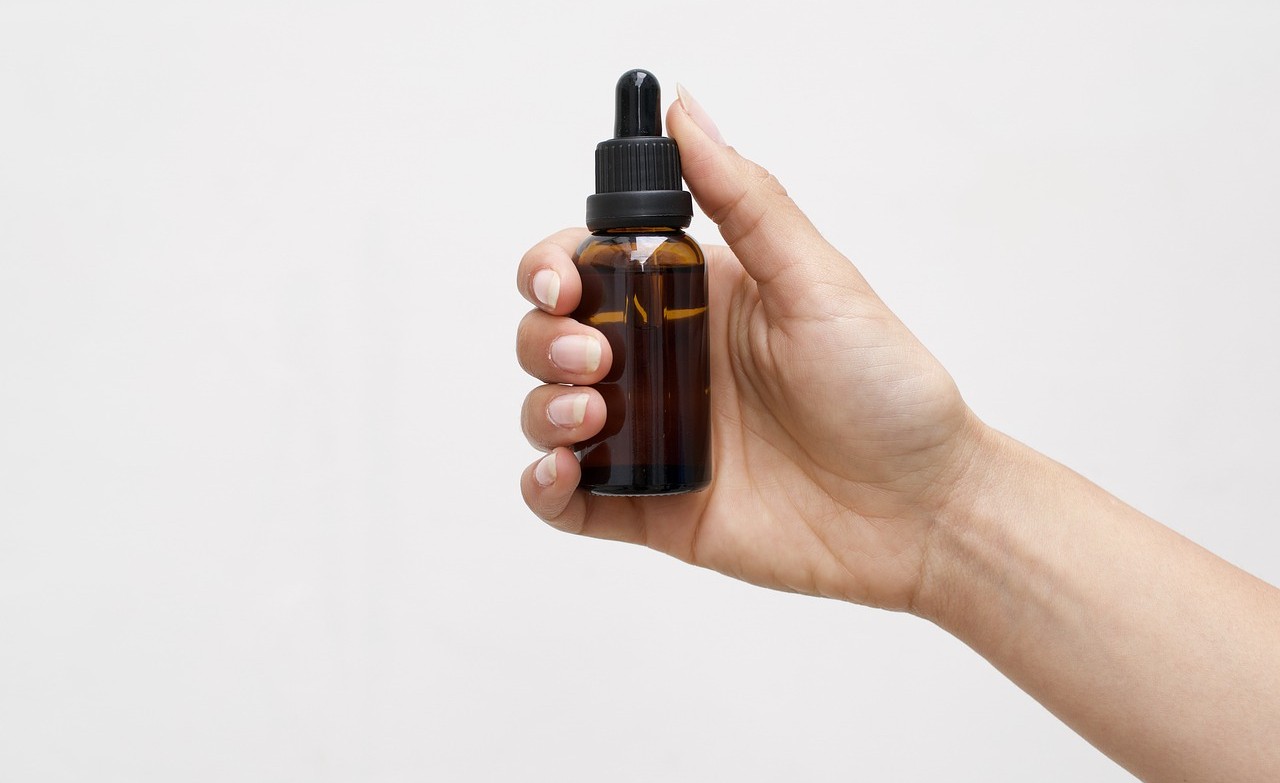 bottle with cbd oil in a woman's hand