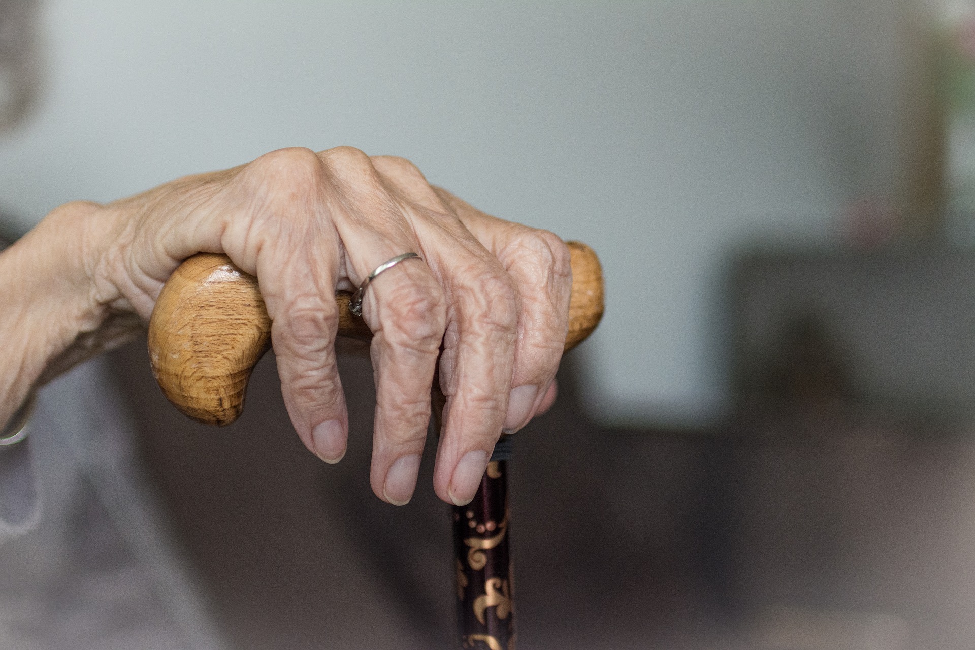 hand of an elderly woman on a walking stick