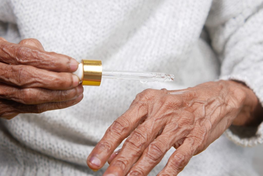 person holding yellow and silver tube with cbd oil