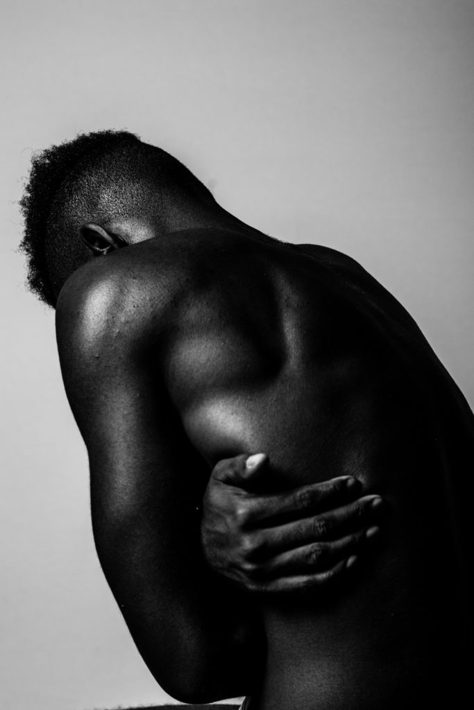 photo of a man holding his rib in pain